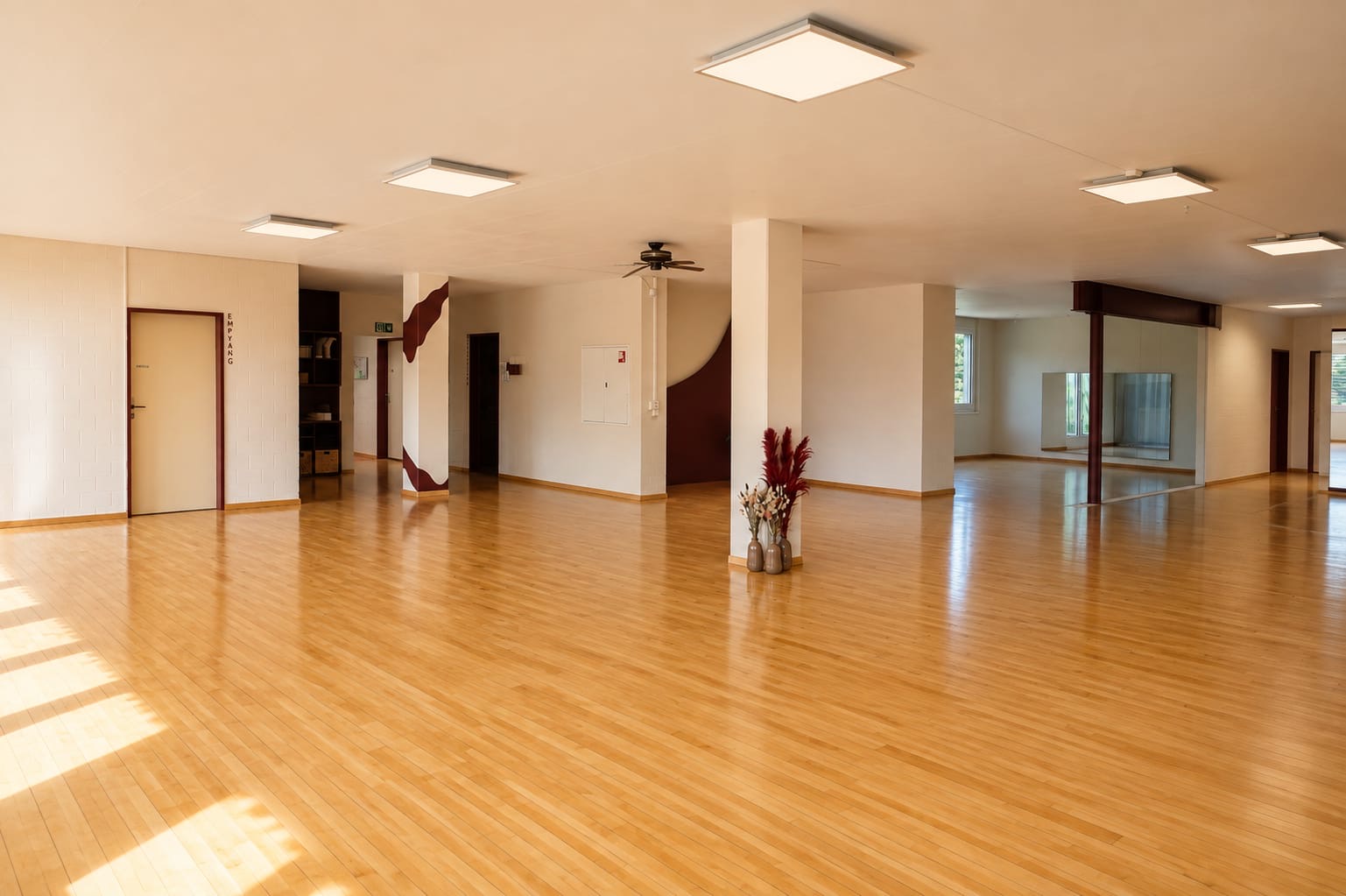 Hauptsaal des PULSANA Studios in Gipf-Oberfrick mit Holzparkett und burgunderfarbenen Wandelementen